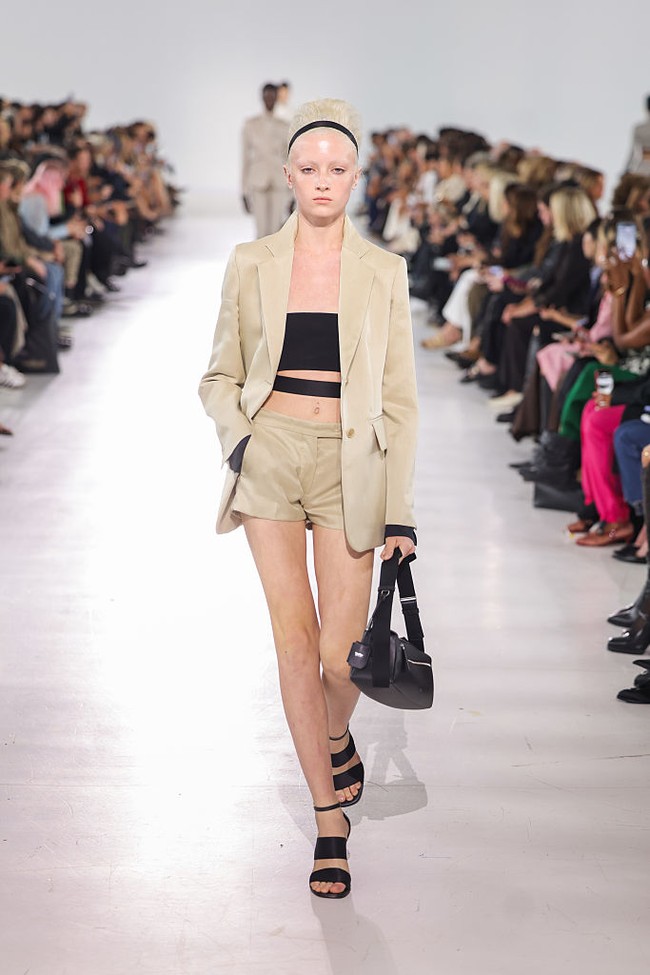 Kai yang terlahir sebagai laki-laki dan kini jadi transgender mengalami hal tak terduga saat memeragakan koleksi Max Mara Spring/Summer 2026. Crop top hitam yang dipakainya melorot. Foto: Dok. Getty Images, Instagram Kai Schreiber