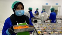 Enung yang merupakan warga sekitar direkrut menjadi salah satu relawan. Tuganya memasukkan sayuran ke tray food yang digelar di atas meja.