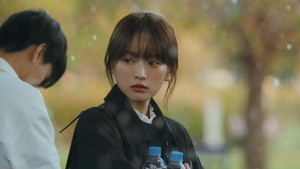 Momen Sung Je Yeon memeluk dua botol minuman saat berteduh dari hujan. Kira-kira Sunwoo Hae ke mana? (Foto: dok. JTBC)