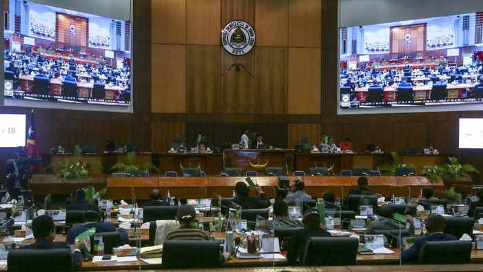 East Timorese members of parliament raise their hands to vote on a lifetime monthly pension for MPs at the National Parliament in Dili on September 25, 2025, where the vote resulted in 51-0 in favour of abolishing the pension. (Photo by Valentino Dariell DE SOUSA / AFP)