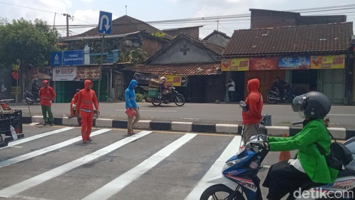 Petugas membuat marka kejut di jalan Jogja-Solo simpang tiga Popongan, Jumat (26/9/2025).