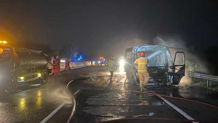 Petugas saat menangani Isuzu Elf yang terbakar