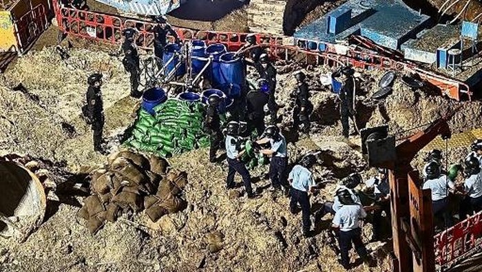 This handout taken and released on September 20, 2025 by the Hong Kong Police Force via their Facebook page shows police personnel, including members of the explosive ordnance disposal team (top, in black), making preparations to defuse a World War II-era bomb at a construction site in the Quarry Bay neighbourhood of Hong Kong. Hong Kong authorities have evacuated thousands of residents over a bomb left over from World War II that was discovered at a construction site. Police said the bomb -- found on September 19 -- weighed about 450 kilograms (1,000 pounds), adding that they believed it remained fully functional and could have caused mass casualties if mishandled. (Photo by Handout / HONG KONG POLICE FORCE / AFP) / RESTRICTED TO EDITORIAL USE - MANDATORY CREDIT AFP PHOTO / HONG KONG POLICE FORCE - NO MARKETING - NO ADVERTISING CAMPAIGNS - DISTRIBUTED AS A SERVICE TO CLIENTS