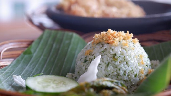Lime leaves rice on a plate that is on banana leaves.