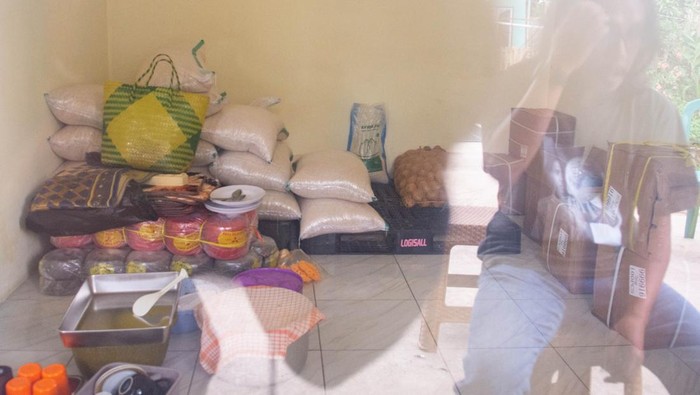 Jurnalis melintas di depan kendaraan pengantar makan bergizi gratis (MBG) di fasilitas Satuan Pelayanan Pemenuhan Gizi dapur Makmur Jaya di Cipongkor, Kabupaten Bandung Barat, Jawa Barat, Jumat (26/9/2025). Pemerintah Kabupaten Bandung Barat menutup sementara tiga dapur penyedia makanan program Makan Bergizi Gratis (MBG) yang diduga menjadi penyebab keracunan massal siswa di Kecamatan Cipongkor hingga keluarnya hasil uji laboratorium dan evaluasi dari Badan Gizi Nasional (BGN). ANTARA FOTO/Novrian Arbi/rwa.