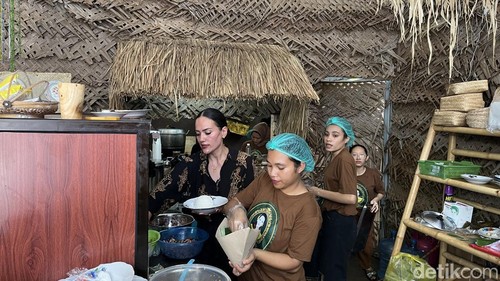 Finalis Miss Indonesia, Wayan Macrae, ikut membantu para pegawainya menyajikan makanan di Paon Mbok Yan, Denpasar, Bali, Minggu (28/9/2025). (Foto: Rizki Setyo/detikBali)