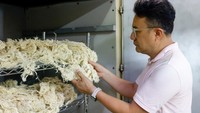 Nelson Yang, pendiri dan manajer umum Farm to Material, memeriksa serat yang terbuat dari batang semu pisang. Material inovatif ini menawarkan alternatif berkelanjutan bagi industri fesyen. Foto: REUTERS/Ann Wang