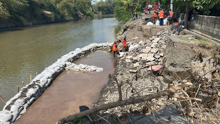 Dinas PUPR memang kisdam karung pasir di Muara Tukad Ayung, Desa Kesiman Kertalangu, Denpasar, Bali pada Minggu (28/9/2025).