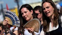 Pengunjung antusias menyaksikan parade kostum meski sambil kipas-kipas. Foto: REUTERS/Angelika Warmuth