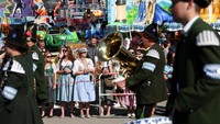 Warga dan wisatawan antusias berfoto dengan peserta parade, sementara pakaian tradisional Bavaria mempertegas identitas lokal yang kuat. Foto: REUTERS/Maryam Majd