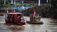 Deretan perahu dari botol plastik bekas mulai berlayar di Sungai Ciliwung, kawasan MT Haryono, Jakarta Selatan, Minggu (28/9/2025).