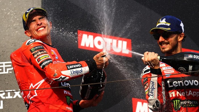 MotoGP - Japanese Grand Prix - Mobility Resort Motegi, Motegi, Japan - September 28, 2025 Ducati Lenovo Teams Francesco Bagnaia celebrates with champagne on the podium after winning the Japanese Grand Prix with second placed Ducati Lenovo Teams Marc Marquez REUTERS/Kim Kyung-Hoon