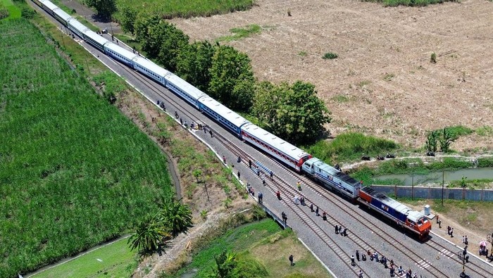 Foto udara warga melihat parade kereta penumpang dengan 11 Livery di Stasiun Tulangan, Sidoarjo, Jawa Timur, Minggu (28/9/2025). Museum Rekor-Dunia Indonesia (MURI) mencatat dua penghargaan berupa parade kereta penumpang dengan 11 Livery terbanyak dari masa ke masa dan fashion show pakaian adat nusantara pertama di atas kereta yang sedang melaju. ANTARA FOTO/Umarul Faruq/foc.