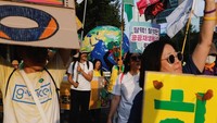 Para peserta membawa spanduk berisi seruan penghentian penggunaan batu bara dan pengurangan polusi plastik di tengah pawai iklim terbesar tahun ini. Foto: REUTERS/Soo-hyeon Kim