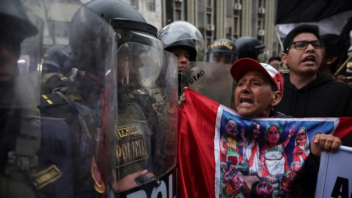 Protesters face police officers during a demonstration organised by a youth collective called 