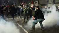 Polisi anti huru hara menembakkan gas air mata saat mereka menggiring sekelompok demonstran menjauh dari sebuah jalan di Lima. Foto: REUTERS/Angela Ponce