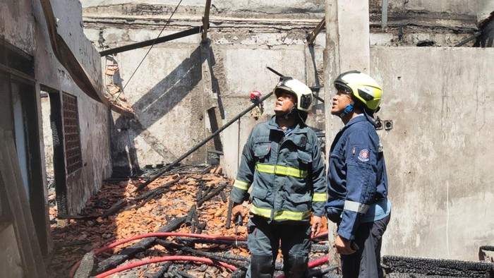 Petugas saat memadamkan api yang melahap rumah kosong di Jalan Raya Darmo Baru Barat Nomor 53 Sukomanunggal, Surabaya