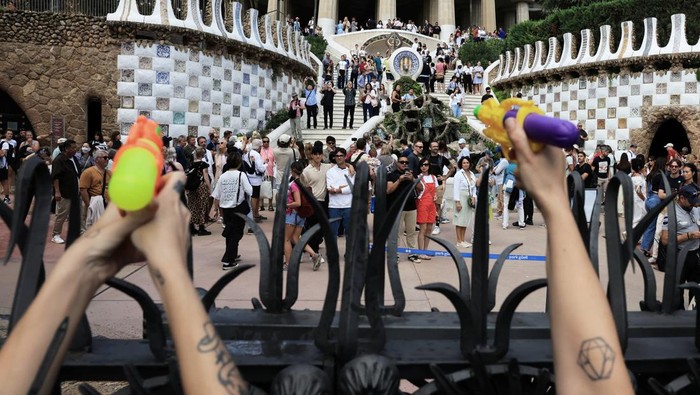 Anti-tourism activists use water pistols during a protest against mass tourism in front of the Park Guell on World Tourism Day in Barcelona, Spain, September 27, 2025. REUTERS/Nacho Doce