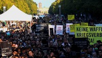 Sejumlah demonstran membawa spanduk bertuliskan “Boikot Israel” saat long march dari Menara TV menuju Kolom Kemenangan di Tiergarten. Foto: REUTERS/Christian Mang