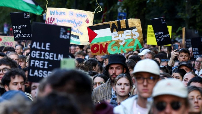 Demonstrators light mobile phones flashlights during the 