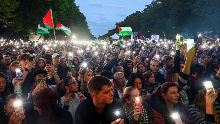 Demonstrators light mobile phones flashlights during the 