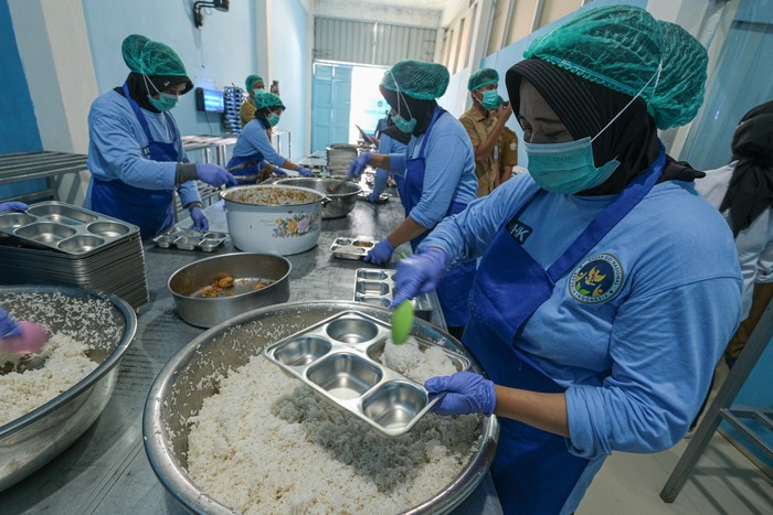 Sejumlah petugas SPPG mengisi makanan ke dalam nampan Makan Bergizi Gratis (MBG) di SPPG Tunggala Kendari, Sulawesi Tenggara, Senin (29/9/2025). Badan Gizi Nasional (BGN) Regional Sulawesi Tenggara mencatat per 18 September 2025, sebanyak 106 dapur S