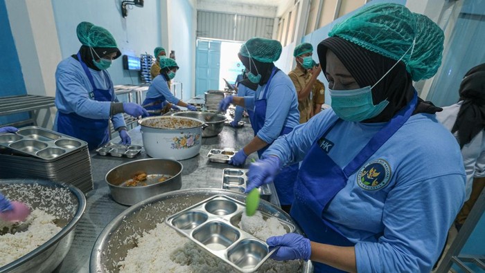 Sejumlah petugas SPPG mengisi makanan ke dalam nampan Makan Bergizi Gratis (MBG) di SPPG Tunggala Kendari, Sulawesi Tenggara, Senin (29/9/2025). Badan Gizi Nasional (BGN) Regional Sulawesi Tenggara mencatat per 18 September 2025, sebanyak 106 dapur Satuan Pelayanan Pemenuhan Gizi (SPPG) telah beroperasi di 16 kabupaten dan kota se-Sulawesi Tenggara dengan setiap SPPG melayani sebanyak 3.000 hingga 3.500 penerima manfaat. ANTARA FOTO/Andry Denisah