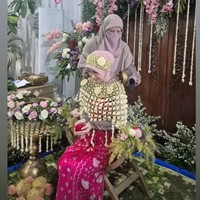 Saat prosesi siraman, Adiba berganti pakaian mengenakan kain jumputan berwarna shock pink dan roncean melati. Terlihat Umi Pipik yang ikut menuangkan air siraman ke sang putri. Foto: Instagram/@_ummi_pipik_