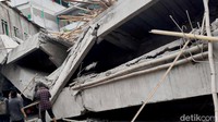 Sejumlah petugas gabungan sedang melakukan evakuasi korban diduga tertimpa bangunan ambruk.