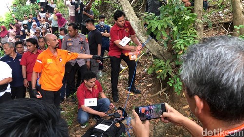 Dua Mr X saat memperagakan adegan mengikat leher Brigadir Esco di bukit belakang rumah tersangka Briptu Rizka, Senin (29/9/2025). (Foto: M Zahiruddin/detikBali)