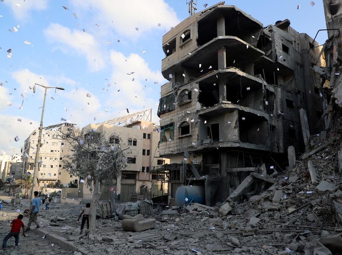 Leaflets that were dropped by Israeli forces, ordering residents of Gaza City to evacuate, fall next to a damaged building, in Gaza City, September 29, 2025. REUTERS/Ebrahim Hajjaj     TPX IMAGES OF THE DAY