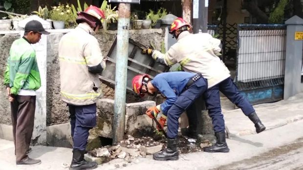 Kepulan asap muncul dari bawah tiang lampu di Sukmajaya, Kota Depok, Jawa Barat. Damkar bersama pihak terkait turun tangan menangani masalah itu. (dok Damkar Depok)