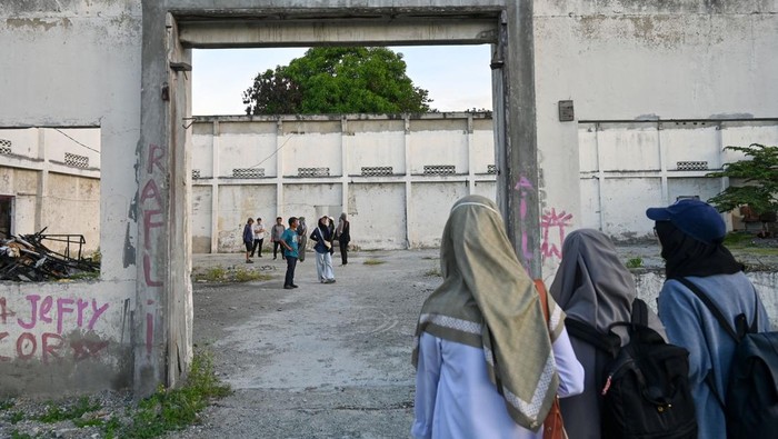 Sejumlah peserta berada di dalam sisa-sisa bangunan Taman Hiburan Umum (THU) yang dibangun pada tahun 1920-an pada tur wisata sejarah dengan berjalan kaki (walking tour) di Palu, Sulawesi Tengah, Senin (29/9/2025). Tur wisata yang diinisiasi Komunitas Historia Sulteng dan diikuti puluhan peserta itu merupakan bagian dari implementasi wisata dengan minat khusus sekaligus mengenalkan mengenalkan sejarah, entitas wilayah, serta ingatan kolektif atas obyek yang dikunjungi, peristiwa unik dan jejak kebencanaan pada bentang alam sekitarnya. ANTARA FOTO/Basri Marzuki/nz