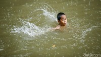 Sesekali batu hingga pecahan kaca ditemukan anak-anak di aliran Kalimalang tempat mereka berenang.