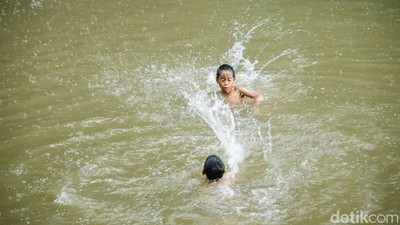Potret Anak-anak Asyik Berenang di Kalimalang Saat Hujan