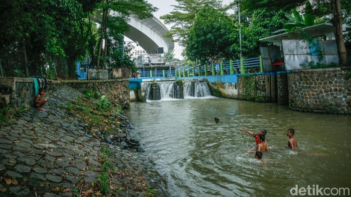 Sejumlah anak berenang di aliran Kalimalang, Jakarta, meski hujan deras mengguyur wilayah tersebut, Senin (29/9/2025).