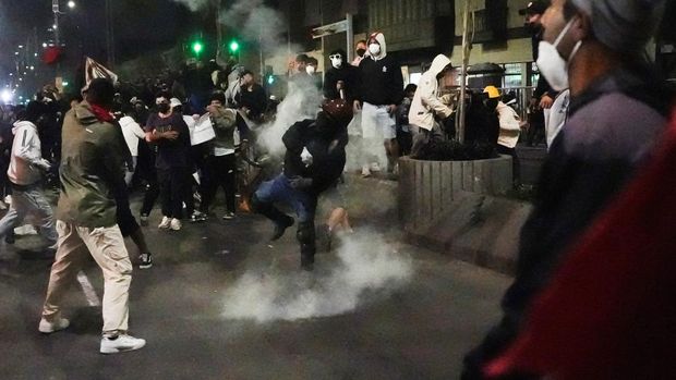 Seorang pengunjuk rasa melemparkan tabung gas air mata selama demonstrasi yang diselenggarakan oleh kolektif pemuda yang disebut 