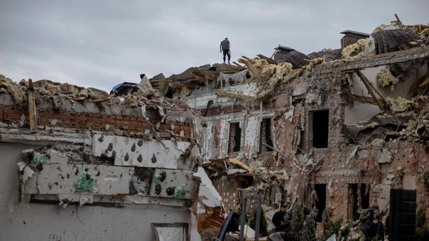 Seorang pria berdiri di atap bangunan tempat tinggal yang hancur akibat serangan pesawat tak berawak dan rudal Rusia, di tengah serangan Rusia terhadap Ukraina, di Kyiv, Ukraina, 28 September 2025. (REUTERS/Thomas Peter)