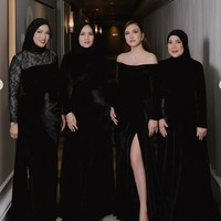 Shandy mengenakan gaun panjang berbahan velvet berwarna hitam yang elegan. Model off-shoulder menonjolkan bahu dan tulang selangka, memberikan kesan anggun sekaligus seksi. Bagian bawah gaun memiliki belahan tinggi di sisi depan yang menambah kesan glamor dan mempertegas siluet tubuh. Foto: Instagram/@shandyaulia
