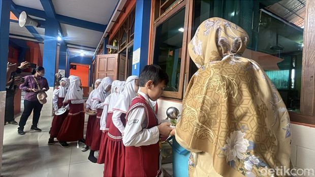 Siswa SD Muhammadiyah 1 Ketelan Solo menerima menu makan siang Rp 10 ribu dari dapur sehat di sekolahnya, Senin (29/9/2025).