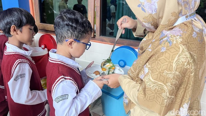 Siswa SD Muhammadiyah 1 Ketelan Solo menerima menu makan siang Rp 10 ribu dari dapur sehat di sekolahnya, Senin (29/9/2025).