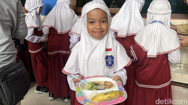 Siswa SD Muhammadiyah 1 Ketelan Solo menerima menu makan siang Rp 10 ribu dari dapur sehat di sekolahnya, Senin (29/9/2025).