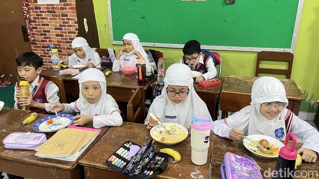 Siswa SD Muhammadiyah 1 Ketelan Solo menerima menu makan siang Rp 10 ribu dari dapur sehat di sekolahnya, Senin (29/9/2025).