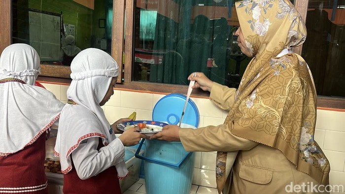 Siswa SD Muhammadiyah 1 Ketelan Solo mengantre makan siang, Senin (29/9/2025).