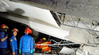 Petugas Damkar sedang memasuki bangunan yang ambruk untuk mencari korban.
