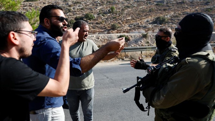 Warga Palestina menggelar aksi protes menolak pembangunan infrastruktur jalan pintas yang dibangun Israel di atas tanah mereka, dekat Ramallah, Tepi Barat, Senin (29/9/2025). Proyek tersebut dinilai semakin mempersempit ruang gerak warga sekaligus memperkuat kontrol Israel atas wilayah pendudukan. REUTERS/Mohamad Torokman