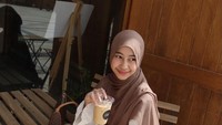 Ini momen Adiba di saah satu kafe yang sayangnya tak diketahui lokasinya. Ia tampak berpose di area depan kafe sambil menikmati segelas es kopi susu. Foto: Instagram/@adiba_knzha