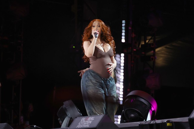 Wanita berdarah Dominika ini tampil dengan tank top berwarna cokelat gelap dengan aksen hijau hutan yang menonjolkan siluet kehamilannya, dipadukan dengan jeans baggy biru bergaya streetwear. Foto: WireImage/Johnny Nunez