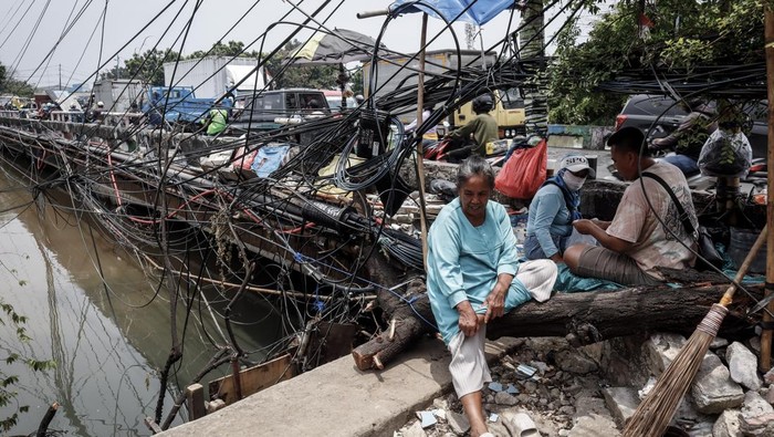 Kabel Semrawut di Jalan Kapuk Ancam Pengguna Jalan Pengendara sepeda motor melintas di samping instalasi kabel utilitas yang semrawut di Jalan Raya Kapuk, Jakarta, Selasa (30/9/2025). Warga setempat mengeluhkan semrawutnya jaringan kabel utilitas di wilayah tersebut karena mengurangi kenyamanan dan keindahan kota, serta berpotensi membahayakan pengguna jalan. ANTARAFOTO/Muhammad Rizky Febriansyah/rwa.
