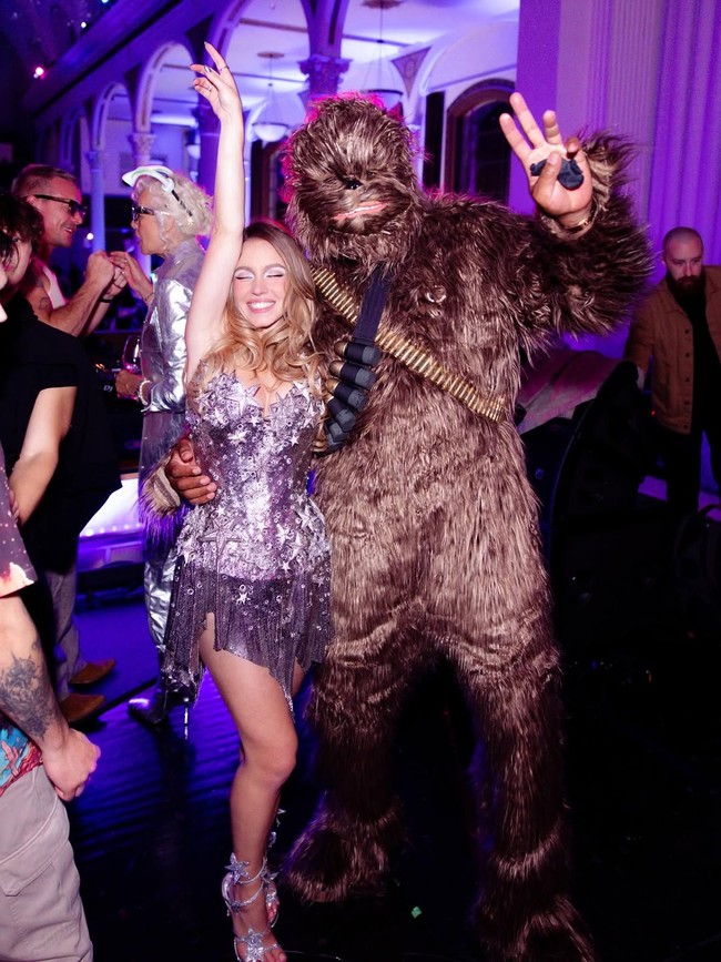 Aktris yang populer lewat serial ‘Euphoria’ tersebut tampil bling bling mengenakan mini dress silver berhias glitter, dan ornamen bintang. Foto: Instagram/@sydney_sweeney